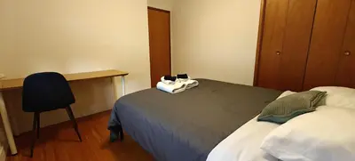 a bedroom with a bed and a desk and a chair at Spacious Family Room with Shared Washroom in Vancouver