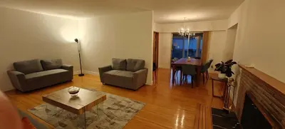 a living room with a couch and a dining room at Spacious Family Room with Shared Washroom in Vancouver