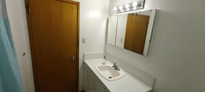 a bathroom with a sink and a mirror at Spacious Family Room with Shared Washroom in Vancouver