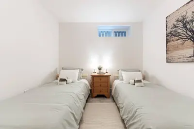 two beds in a room with white walls at Lynn Valley 2BR Suite By Grouse Mtn & Lynn Canyon in North Vancouver