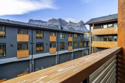 a balcony with a view of some buildings and mountains at Creekside Cove in Spring Creek in Canmore