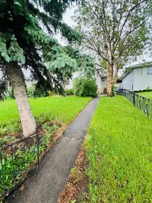 a sidewalk in a yard next to a house at mysev property in Calgary