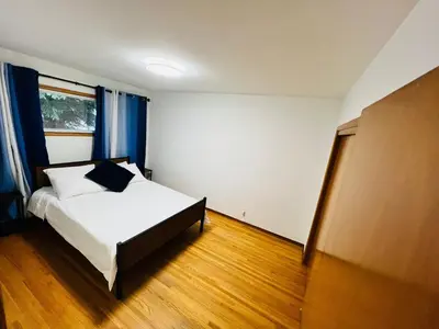 a bedroom with a white bed and blue curtains at mysev property in Calgary