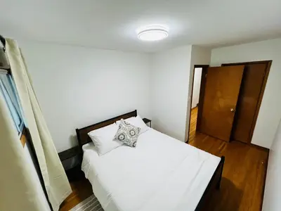 a bedroom with a white bed with a pillow on it at mysev property in Calgary