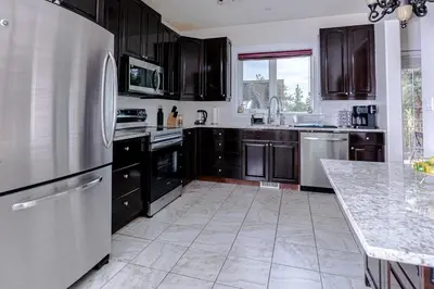 a kitchen with a stainless steel refrigerator and a counter at Northern Solace, 2 beds, 2 baths, 5 min to airport in Yellowknife