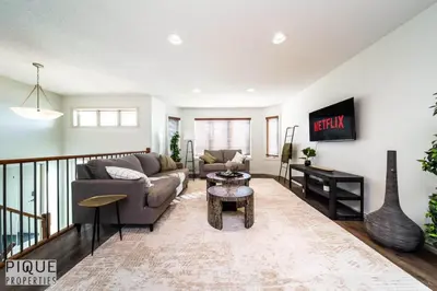 a living room with a couch and a table at 6BDRM Chic Modern Home-Fireplace-BBQ-Sleeps 18! in Edmonton