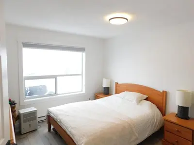 a white bedroom with a bed and a window at Drive Up Condo - Walk to Mount Washington in Mount Washington