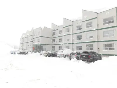 a parking lot covered in snow in front of a building at Drive Up Condo - Walk to Mount Washington in Mount Washington