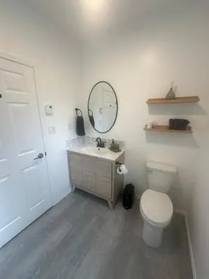 a bathroom with a toilet and a sink and a mirror at Lake Trail Guesthouse in Victoria