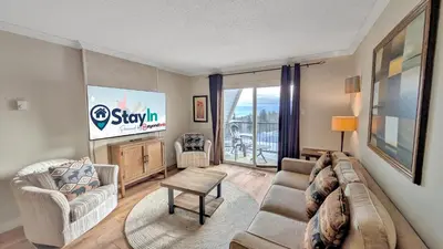 a living room with a couch and a tv at Rocky Mountain Condos by StayIn in Kimberley