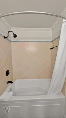 a white bath tub with a shower curtain in a bathroom at Rocky Mountain Condos by StayIn in Kimberley