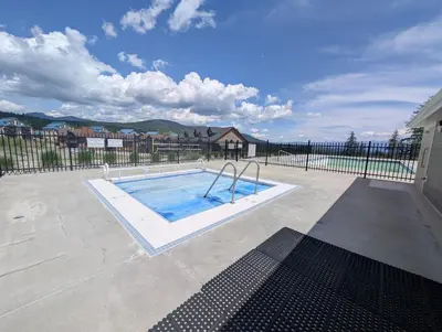 a swimming pool in a yard with a fence at Rocky Mountain Condos by StayIn in Kimberley