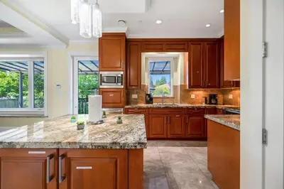 a kitchen with wooden cabinets and granite counter tops at Luxury 4-Bedroom Villa in Vancouver