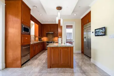 a large kitchen with wooden cabinets and a island at Luxury 4-Bedroom Villa in Vancouver