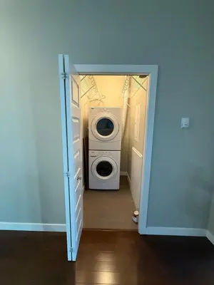 a door to a laundry room with a washer and dryer at Peaceful Condo for Short and Long Term Rental in Edmonton