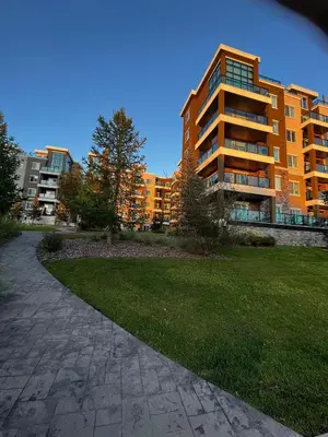a large apartment building with a lawn in front of it at Peaceful Condo for Short and Long Term Rental in Edmonton