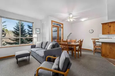 a living room with a couch and a dining room at 2BR in Symphony, Hot Tub, Gas Fireplace, Epic Village Location, Ski Shuttle in Whistler