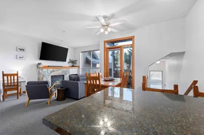 a living room with a ceiling fan and a living room at 2BR in Symphony, Hot Tub, Gas Fireplace, Epic Village Location, Ski Shuttle in Whistler
