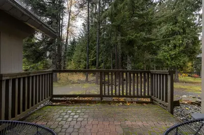 a porch with a wooden fence with chairs on it at 1BR and Sofabed in The Gables, Epic Village Location, Secure Parking, Forest Views in Whistler