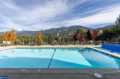 a large swimming pool with mountains in the background at 2BR in Ironwood, Stunning Mountain Views, Shared Hot Tub and Pool, Fireplace, Parking in Whistler