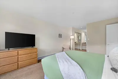 a bedroom with a bed and a flat screen tv at 2BR in Ironwood, Stunning Mountain Views, Shared Hot Tub and Pool, Fireplace, Parking in Whistler