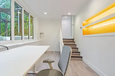 a dining room with a table and chairs and windows at Serene 5-Bedroom Nature Retreat in West Vancouver