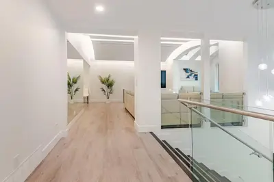 a hallway with white walls and wood floors at Serene 5-Bedroom Nature Retreat in West Vancouver