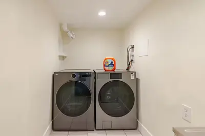 two washing machines sitting next to each other in a room at Serene 5-Bedroom Nature Retreat in West Vancouver