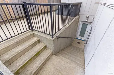a stairway leading to a door in a building at Spacious 1BR Suite Near Capilano Bridge & Trails in North Vancouver