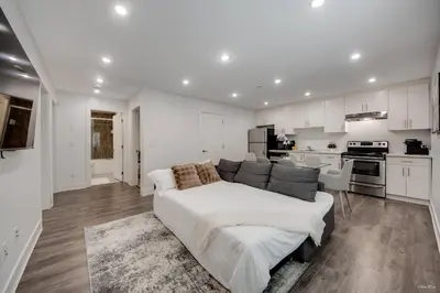 a living room with a couch and a kitchen at Modern 2Bed Suite Near Capilano Bridge & Trails in North Vancouver
