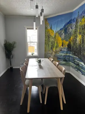 a dining room with a table and chairs and a painting at Character Home near Downtown and 17th Avenue in Calgary