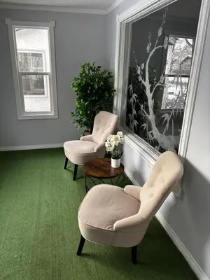 two chairs and a table in a room with green carpet at Character Home near Downtown and 17th Avenue in Calgary