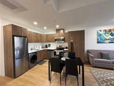 a kitchen and living room with a table and a couch at Apartment in Downtown YEG in Edmonton