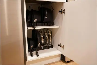 a cupboard filled with lots of black pans at Spacious 3 BDR Suite Sleeps 6 Comfortably in Edmonton