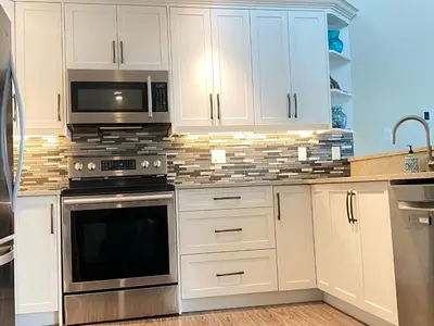 a kitchen with white cabinets and stainless steel appliances at Tanglewood 13 in Parksville