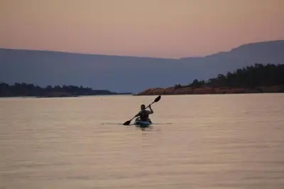 a person holding a paddle in a body of water at Tanglewood 18 in Parksville