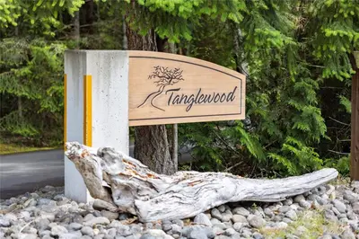 a sign for tamarackventory sitting next to a tree at Tanglewood 19 in Parksville