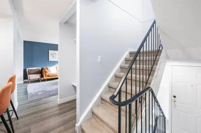 a staircase in a home with white walls and wood floors at WEM Retreat | 3BR | Mins from the Mall in Edmonton