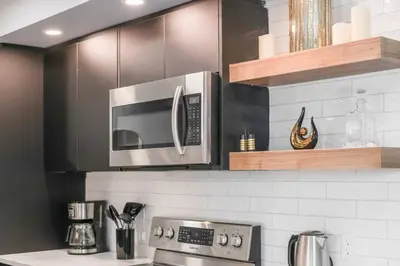 a kitchen with a microwave above a stove at WEM Retreat | 3BR | Mins from the Mall in Edmonton