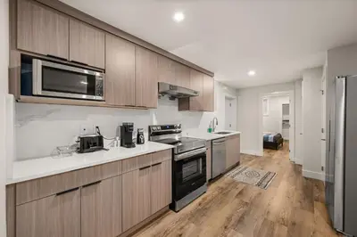 a kitchen with stainless steel appliances and wooden cabinets at Peaceful 2BR Getaway with Fireplace & Parking Basement Suite in Abbotsford