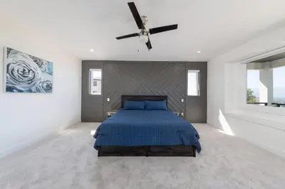 a bedroom with a blue bed and a ceiling fan at Spacious 6BR Home with Terrace Views and Parking nearby parks golf and resorts in Chilliwack