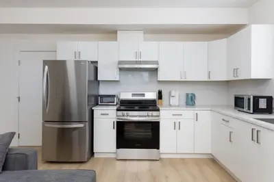 a kitchen with white cabinets and a stainless steel refrigerator at Spacious 6BR Home with Terrace Views and Parking nearby parks golf and resorts in Chilliwack