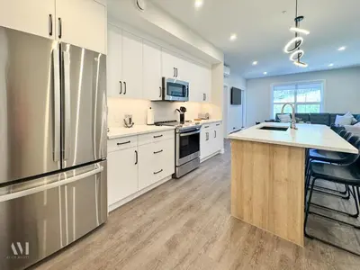 a kitchen with white cabinets and a stainless steel refrigerator at Paradise Point - Hot Tub & Mountain Views in Golden