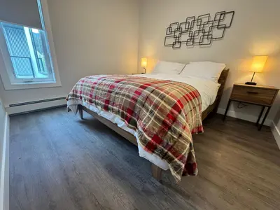 a bedroom with a bed with a plaid blanket at Paradise Point - Hot Tub & Mountain Views in Golden
