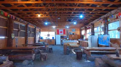 a room with wooden tables and benches in a building at Mountain View Cabins in Golden