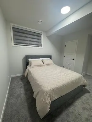 a bedroom with a large bed with a window at Rockies Golden Retreat 2BR Suite at Glacier Ridge NW Calgary in Calgary