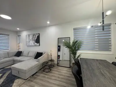 a living room with a couch and a table at Family Friendly Rockies Retreat at Glacier Ridge NW Calgary in Calgary