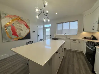 a kitchen with white cabinets and a white counter top at Family Friendly Rockies Retreat at Glacier Ridge NW Calgary in Calgary