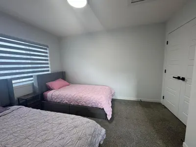 a bedroom with two beds and a window at Family Friendly Rockies Retreat at Glacier Ridge NW Calgary in Calgary
