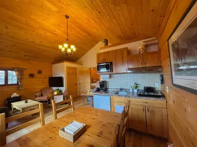 a kitchen and dining room with a wooden ceiling at Radium Cabins Centrally located in Radium Hot Springs BC in Radium Hot Springs